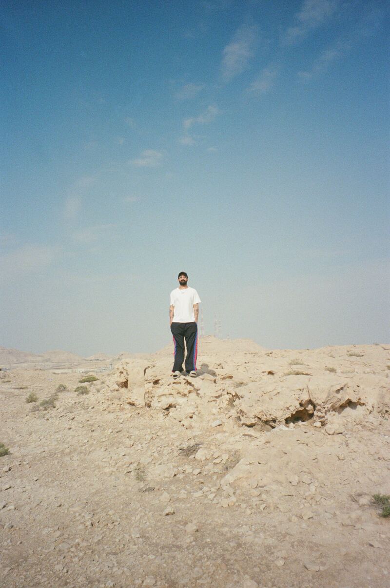 A figure standing on a rocky ridge under a wide desert sky